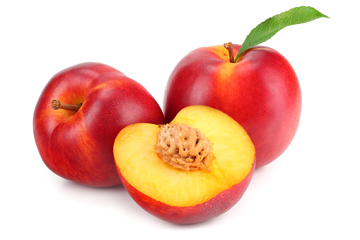 Nectarine with green leaf and slices isolated on white background