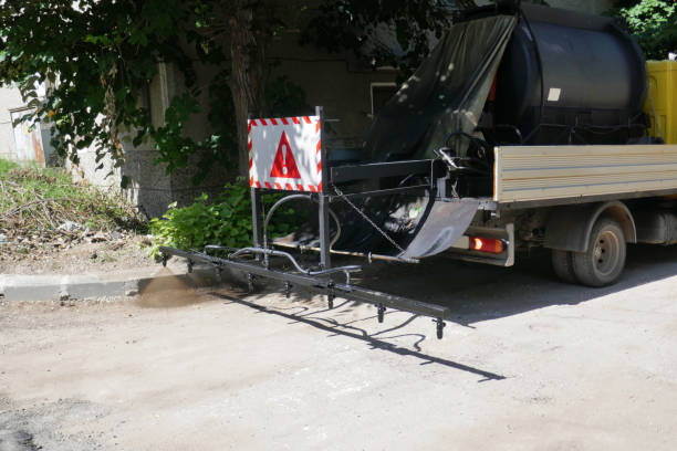 istock Oil spreader truck applying tack coats spraying bitumen emulsion with  spray lance before applying a new layer of asphalt 1162499005
