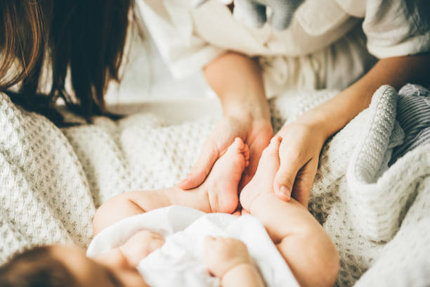 pies de bebé en las manos de la madre. - newborn baby human foot photography fotografías e imágenes de stock