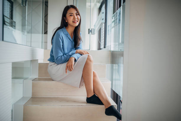 istock Taiwanese woman sitting on steps in apartment 1162509501