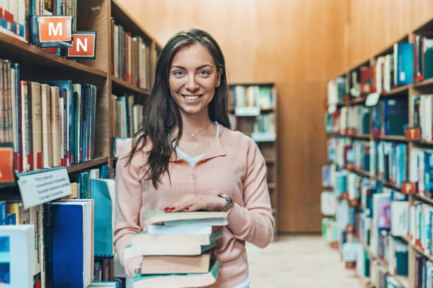 istock Smiling girl in a library 1162510328