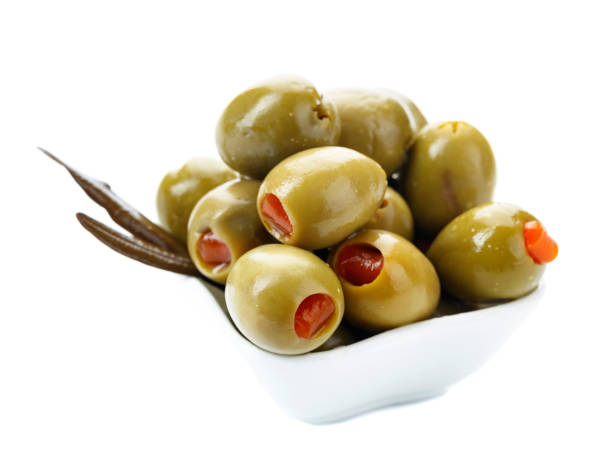 istock Green olives stuffed with red paprika isolated on white. 1162510966