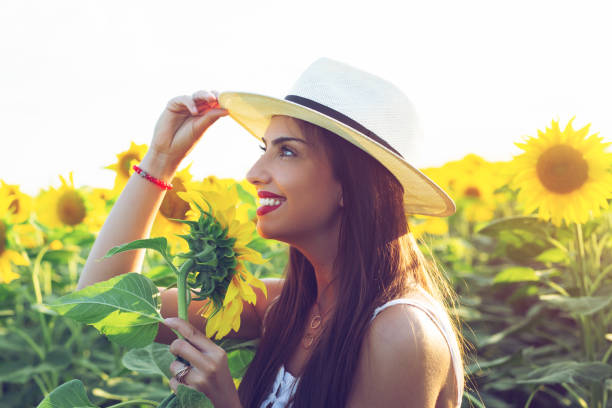 istock Woman With Hat in a Sunflower Field 1162513734