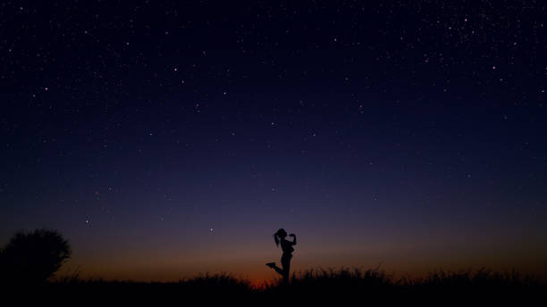 istock Young woman dancing under the starry sky 1162515818