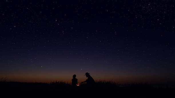 istock Young people sitting by the campfire at the night 1162515819