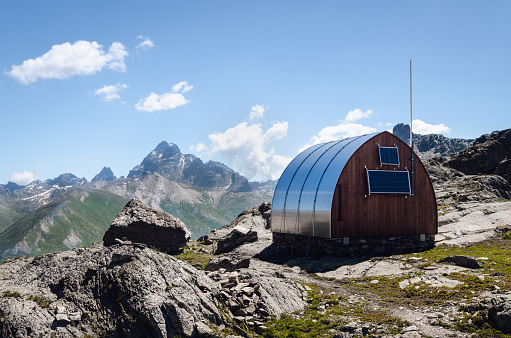 Exterior of the mountain bivouac (free sleeping shelter) on the longet pass, in the piedmontese alps (Italy), facing the famous peak of Monviso (Mount Viso)