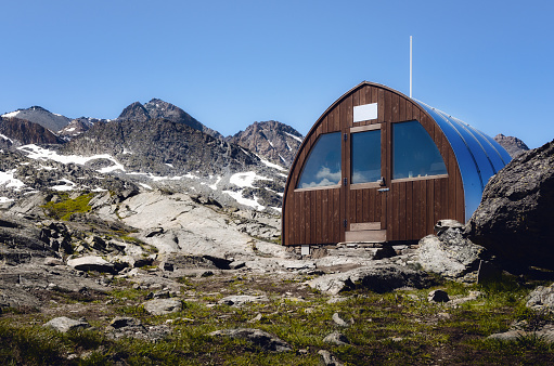 Exterior of the mountain bivouac (free sleeping shelter) on the longet pass, in the piedmontese alps (Italy), facing the famous peak of Monviso (Mount Viso)