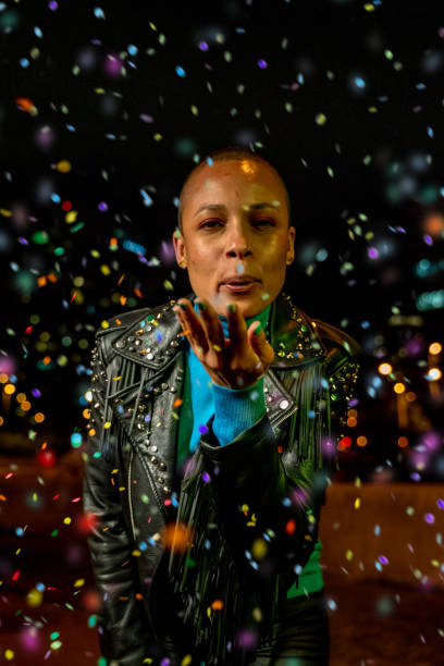 istock Woman blowing confetti outdoors 1162516336