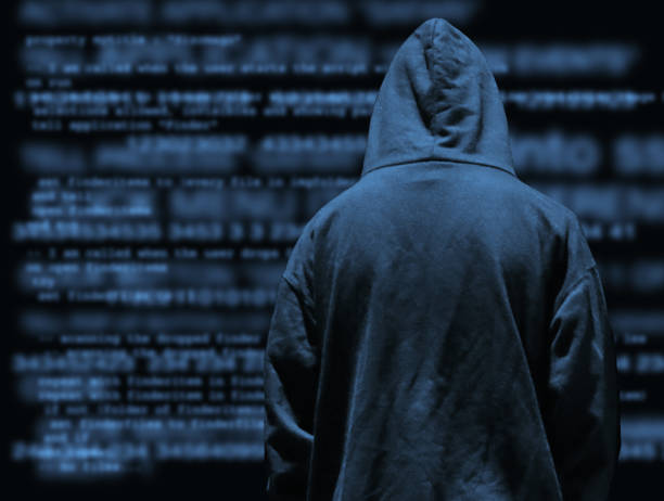 Stock photo of obscured secret computer hacker programmer youth wearing hoodie with dark programming computer code background, concept for cyber war hacking technology, encryption coding, Internet crime, software programming, digital data analysis imagen de los jóvenes programadores de hackers informáticos secretos oscurecidos que llevan sudadera con capucha con fondo de código informático de programación oscura, concepto de tecnología de piratería de guerra cibernética, codificación de cif