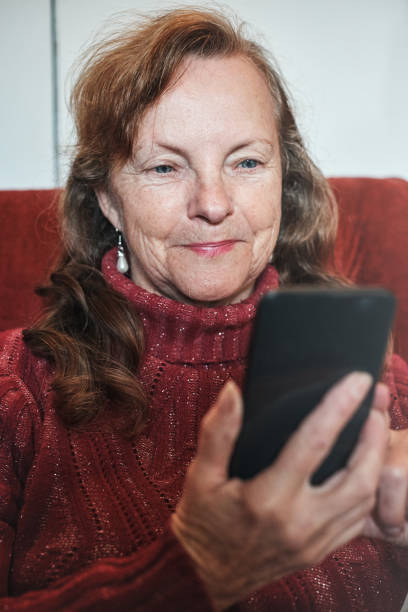istock Smiling senior woman sending text on her smart phone 1162519414