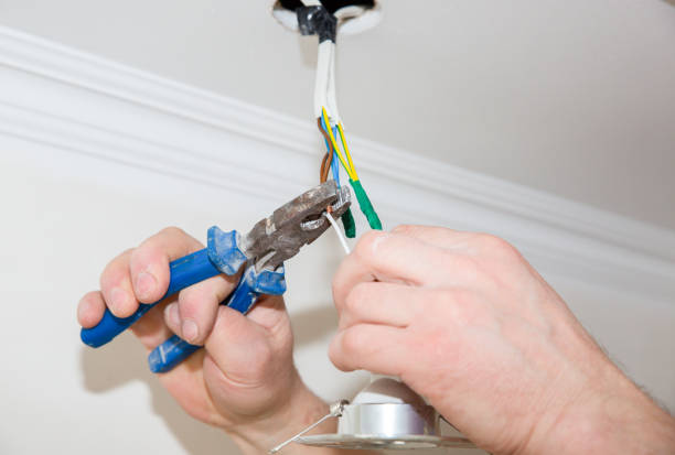 istock Man is holding pliers in his hands. Electrical insulator for light bulb. Adhesive tape for maintenance repair works in the flat. Restoration indoors. 1162519901