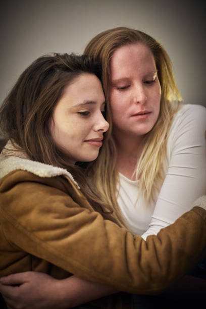 istock Two young women embrace, consoling each other 1162523155