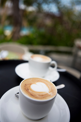 Close up photo of waiter serving coffee to customer in cafe, selective focus