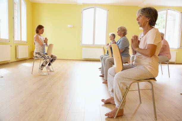 istock Yoga class: Senior women exercising on chair 1162524516