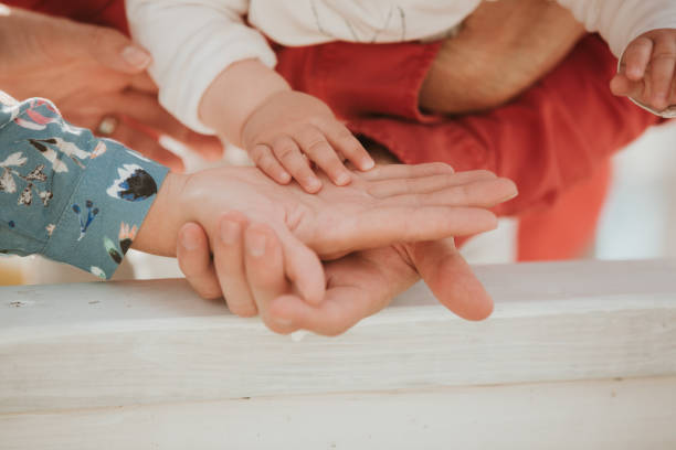istock Mom and Dad hold baby's hand. Children's handle 1162525879