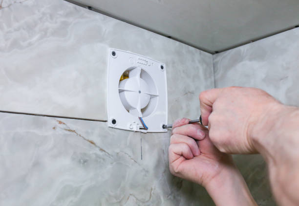 istock Man is making the wall bathroom fan vent. Restoration process. Screwdriver in hands. 1162526013
