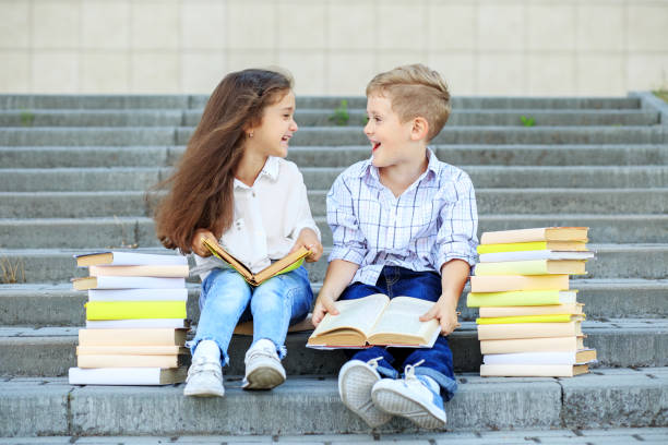 istock Two students read books and communicate. The concept is back to school, education, reading, friendship and family 1162526354