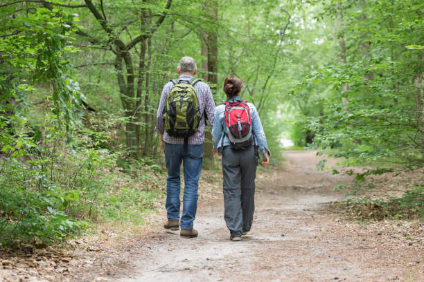 istock Hiking - senior couple walking through the forest 1162530878