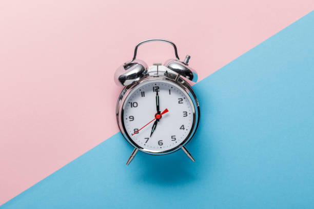 istock top view of classic silver alarm clock on pink and blue background 1162531005