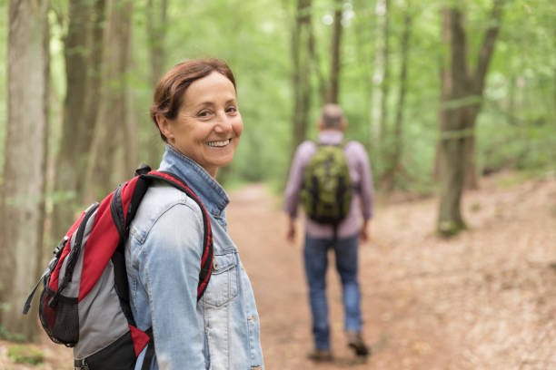 istock Hiking - senior couple walking through the forest 1162531034