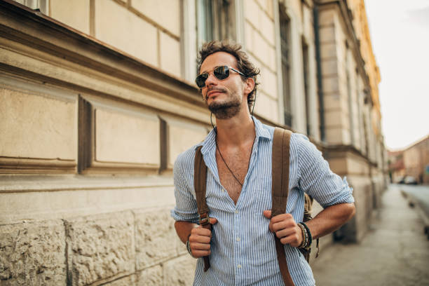 istock Charming young man with backpack on the street 1162531233