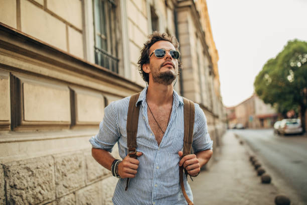 istock Modern young man with backpack on the street 1162531237