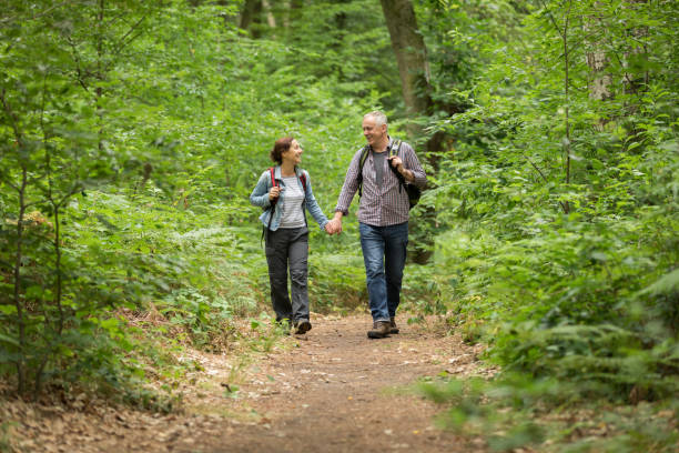 istock Hiking - senior couple walking through the forest 1162531601