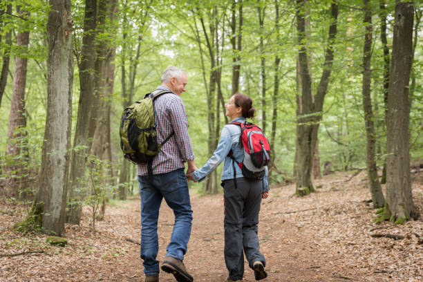 istock Hiking - senior couple walking through the forest 1162532176