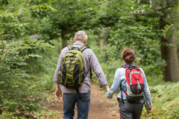 istock Hiking - senior couple walking through the forest 1162532185
