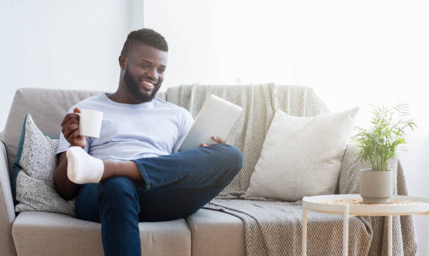 istock African-american millennial guy reading news on tablet and having coffee 1162532276