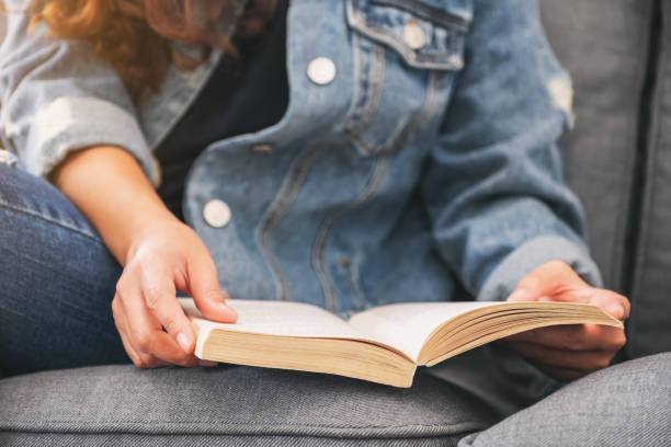 istock a woman sitting and reading a vintage novel book 1162532972