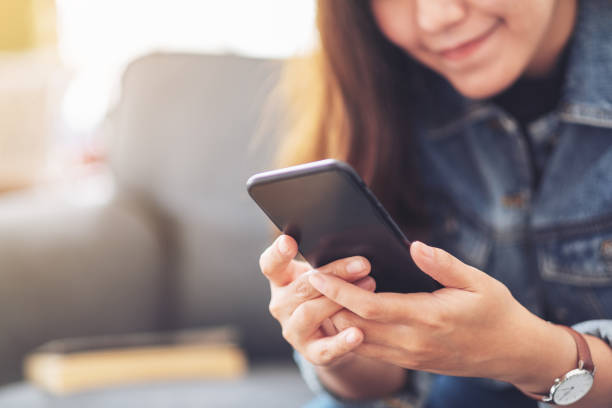 istock a beautiful asian woman holding , using and looking at smart phone 1162533078