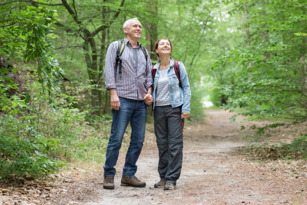 istock Hiking - senior couple walking through the forest 1162535728
