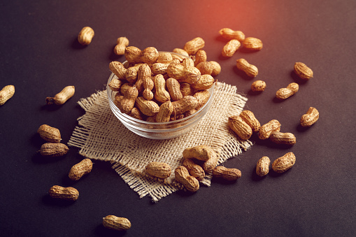 peanuts in bowl on the dark background.