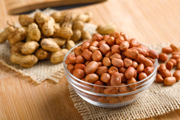 istock peanuts in bowl on the wooden background. 1162540332