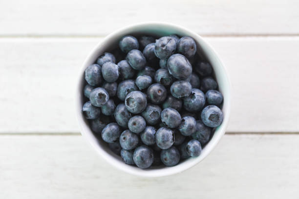 Blueberries in a white bowl on a burlap tablecloth. Juicy blueberries.