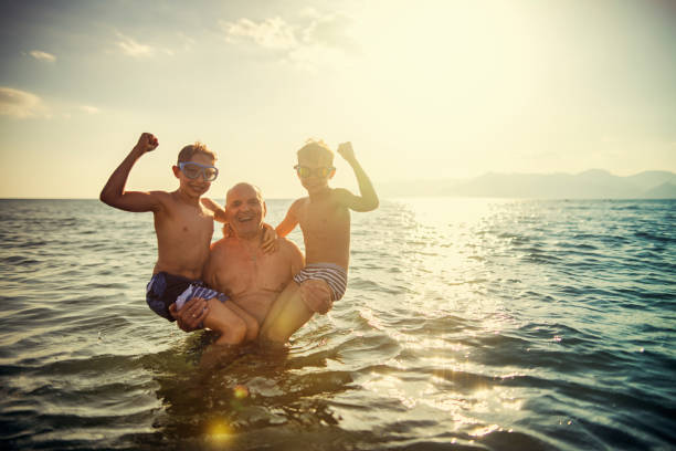 istock Senior man playing with grandsons in sea 1162543979