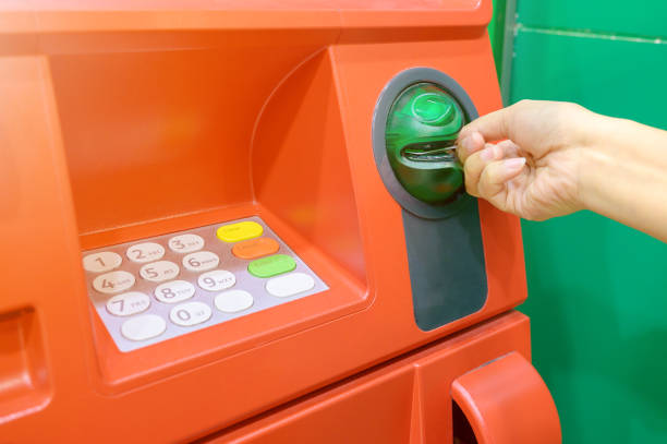 istock Hand of female insert debit card into automated teller machine (ATM) 1162545617