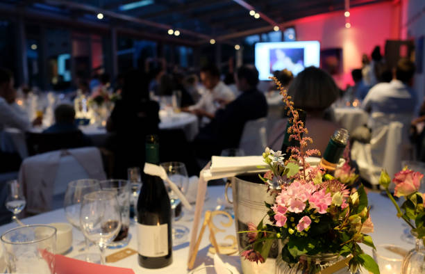 Evening event, conference, wedding, gala Evening event with flowers and wine bottles on the tables gala dinner table stock pictures, royalty-free photos & images