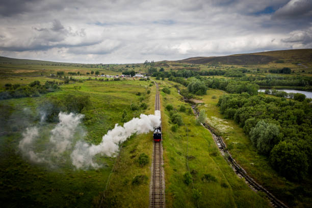 Aerial view of a Steam Train Aerial view of Landscape with steam train of the heritage railway in Blaenavon driving along Garn Lakes Local Reservce in Wales, UK wales mountain mountain range hill stock pictures, royalty-free photos & images