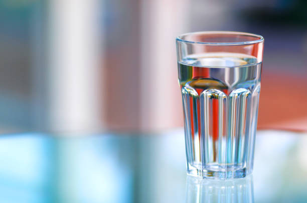 A glass of water on glass table with blurred background