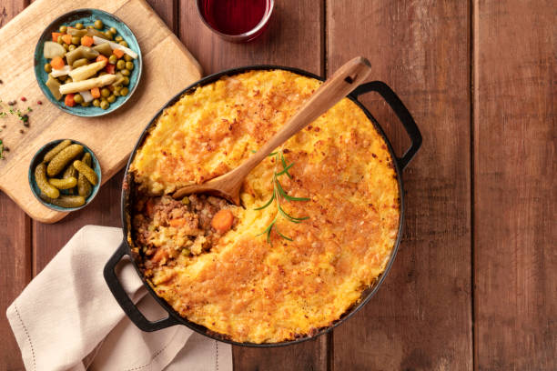 istock Shepherd's pie with pickles and red wine on a rustic wooden background, top shot 1162548860