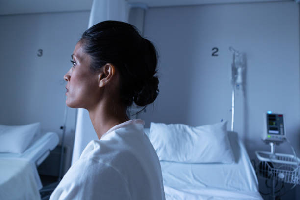 istock Female patient looking away while sitting on bed in ward 1162550252