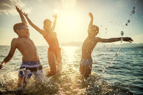 istock Kids jumping and having fun running in sea 1162552579