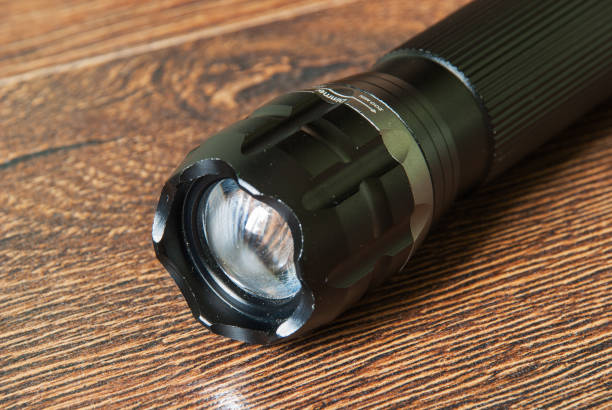 карманный светодиодный фонарик крупным планом на темном фоне. - black flashlight light bulb electricity стоковые фото и изображения