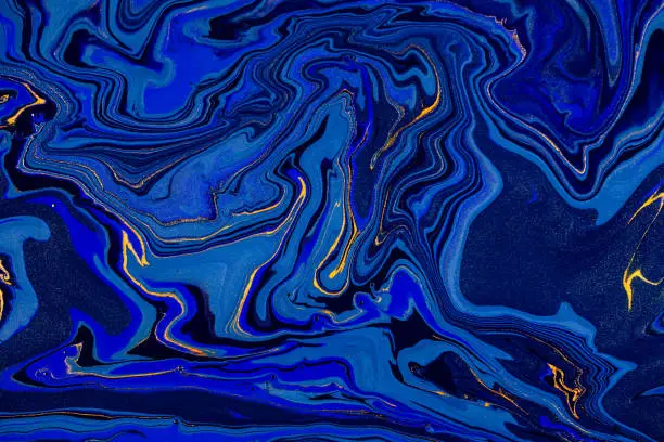 Photo of Hand painted background with mixed liquid blue and golden paints. Abstract fluid acrylic painting. Modern art. Marbled blue abstract background. Liquid marble pattern