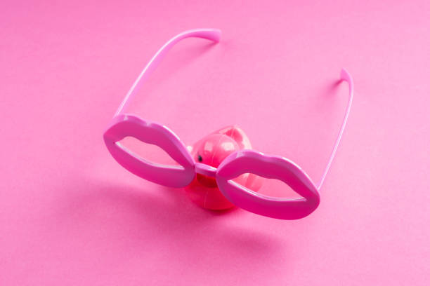 Eyeglasses with mini cup on colored background. Optical store, vision test, stylish glasses concept.