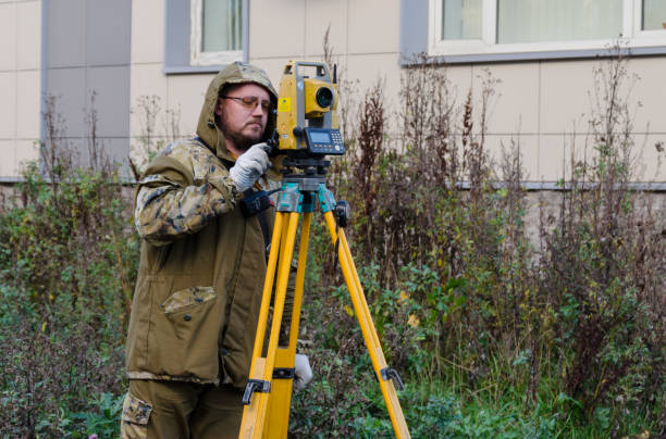 surveyor worker with theodolite - levelling instrument imagens e fotografias de stock