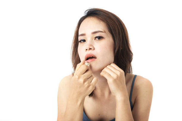 istock Young woman applying beautiful lipstick on gray background 1162558067