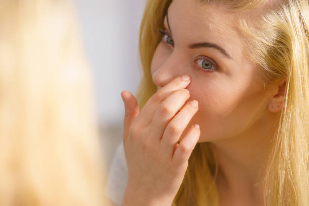 istock Woman looking at her skin in mirror 1162560597